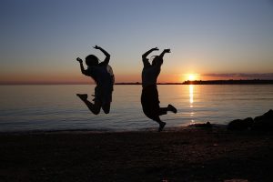two couple taking a jump shot beside the beach