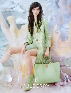 a lady model in green dress and bag